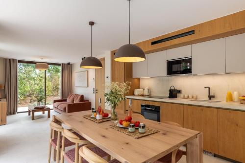 a kitchen and living room with a wooden table at Les Maisons Du Sud in Saint-Tropez