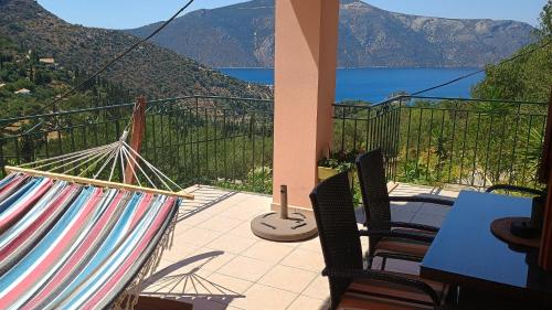 a patio with chairs and a hammock on a balcony at IthakiHouse II in Vathi, Ithaka