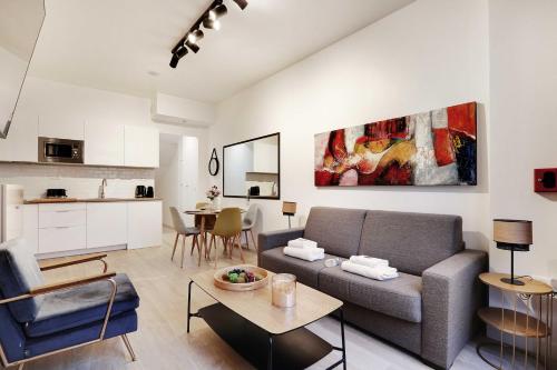 un salon avec un canapé et une table dans l'établissement Intimate Apartment with Air Conditioner & Jacuzzi 2BR 6P Montmartre, à Paris