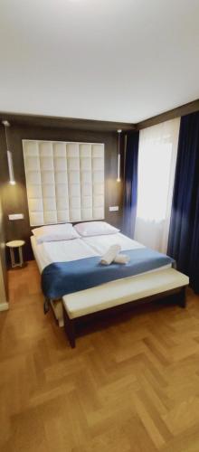a bedroom with a large bed with a wooden floor at Willa Nova in Wisła