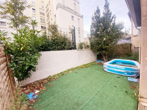 un frisbee bleu posé sur l'herbe dans une cour dans l'établissement Maison familiale JO 2024, à Bondy