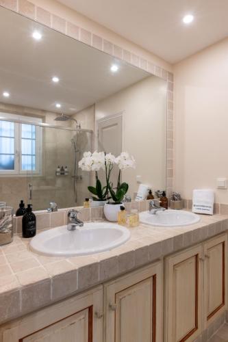 a bathroom with two sinks and a large mirror at Les Maisons Du Sud in Saint-Tropez