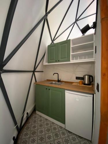 a kitchen with green cabinets and a sink in a room at Evaland Glamping Resort in Kuvançari