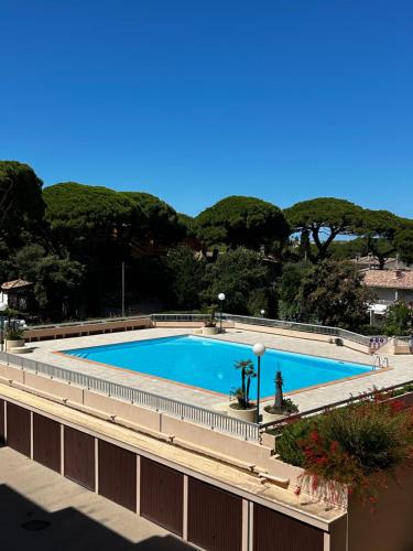 une piscine vide avec des arbres en arrière-plan dans l'établissement Studio Port de Hyeres Plage et Piscine, à Hyères