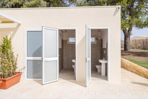 a bathroom with two doors and a toilet at Agrivillage San Lorenzo in San Lorenzo