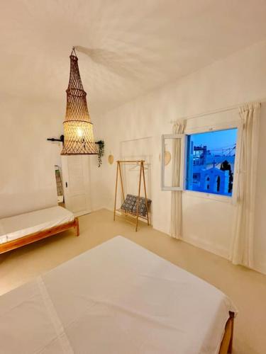 a white room with a bed and a window at Walk The View Apartment with village view in Chora in Ios Chora