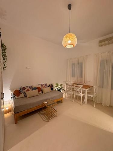 a living room with a couch and a table at Walk The View Apartment with village view in Chora in Ios Chora