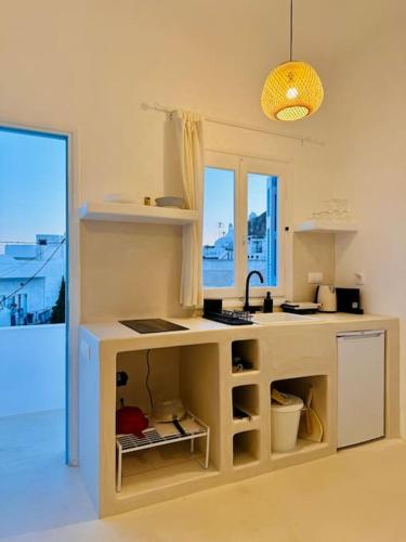 a kitchen with a counter with a sink and a window at Walk The View Apartment with village view in Chora in Ios Chora