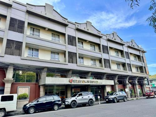 a large building with cars parked in front of it at MO2 Westown Hotel San Juan in Bacolod