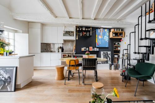 une cuisine et une salle à manger avec une table et des chaises dans l'établissement Veeve - Modern-Chic Mezzanine, à Paris