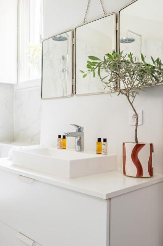 une salle de bain avec un lavabo blanc et un miroir dans l'établissement Veeve - Modern-Chic Mezzanine, à Paris