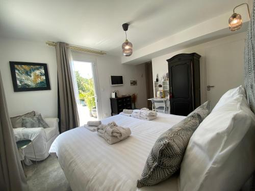 une chambre avec un lit avec des serviettes dessus dans l'établissement Villa Alba en Provence, à Besse-sur-Issole