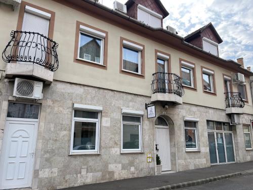 a building with windows and balconies on a street at Pacsirta Apartman Grand in Eger