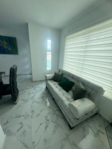 a living room with a couch and a large window at La Roca 201 in Cali