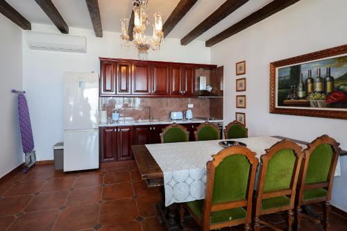 a kitchen with a table and chairs and a refrigerator at Sunrise House - Swimming Pool in Berat