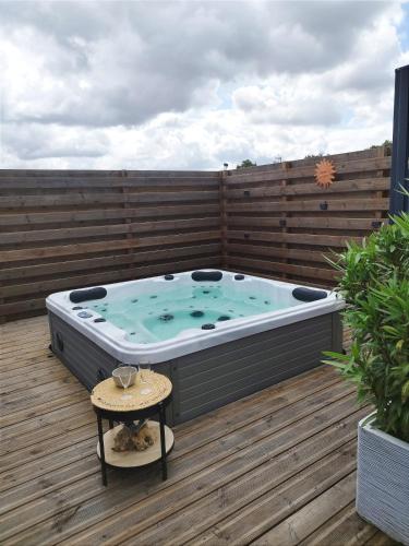 un bain à remous sur une terrasse avec une clôture dans l'établissement Cottage in Premium residence in Sainte-Foy, à Sainte-Foy