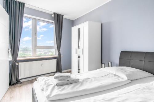 a white bed in a room with a large window at Schleswiger Ausblick in Schleswig