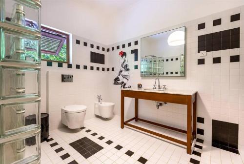 a bathroom with a sink and a toilet and a mirror at Maison de Jardin Villa in Victoria