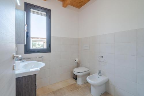 a white bathroom with a toilet and a sink at Agrivillage San Lorenzo in San Lorenzo