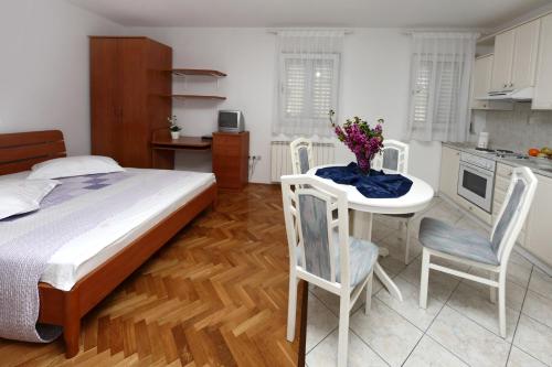 a bedroom with a bed and a table and chairs at Apartments in Beautiful Split in Podstrana