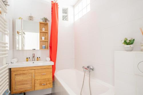 une salle de bain avec une baignoire, un lavabo et une douche dans l'établissement Veeve - Parisian Vistas, à Paris