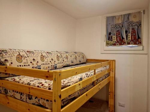 een houten bed in een kamer met een foto aan de muur bij Domu Mea in Quartu SantʼElena