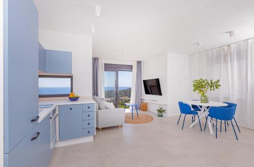a kitchen and living room with a table and blue chairs at House Aqua in Mlini