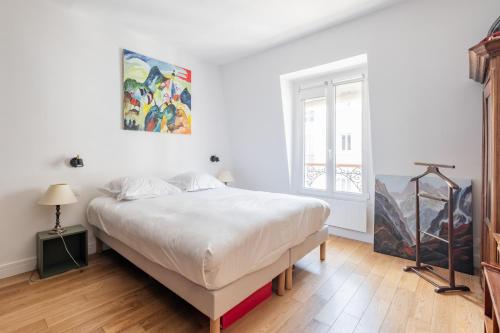 une chambre avec un grand lit et une fenêtre dans l'établissement Veeve - Harmonious Hues, à Paris