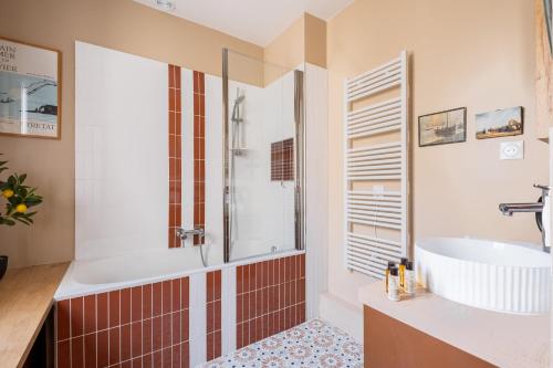 une salle de bain avec une baignoire et un lavabo dans l'établissement Veeve - Harmonious Hues, à Paris