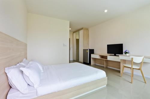 a bedroom with a bed and a desk with a television at Rangh Place in Ban Map Samet Daeng