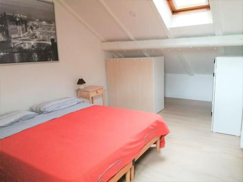 Un dormitorio con una cama roja en una habitación. en Maison Mirt, en Bolonia