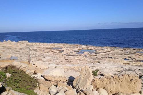 a large group of rocks in front of the ocean at Spacious 4BR Terraced House with Rooftop Access by 360 Estates in Marsaskala