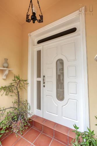 a white door in a room with plants at Spacious 4BR Terraced House with Rooftop Access by 360 Estates in Marsaskala
