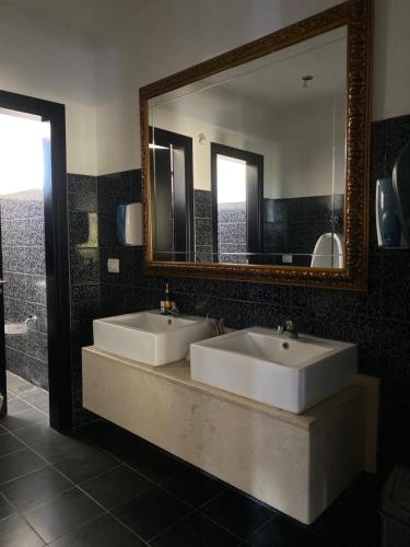 a bathroom with two sinks and a large mirror at Hotel Velipoja Park in Velipojë