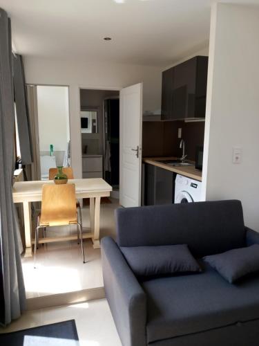 un salon avec un canapé et une table dans l'établissement T2 rdc calme, ensoleillé et fleurie, à Gigean