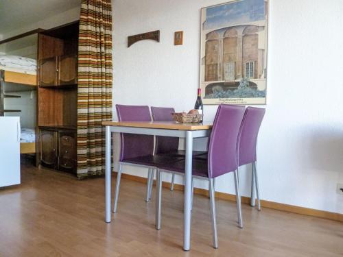 a table with purple chairs in a room at Studio Greppon 110 by Interhome in Les Collons