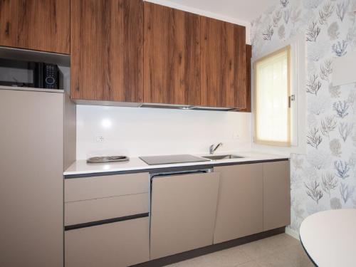 Una cocina con gabinetes blancos y un fregadero. en Holiday Home Tiny House by Interhome, en Lo Stallone