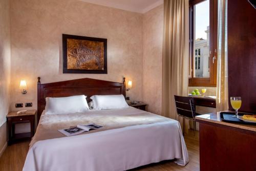 a hotel room with a large bed and a table at Hotel San Francesco in Rome