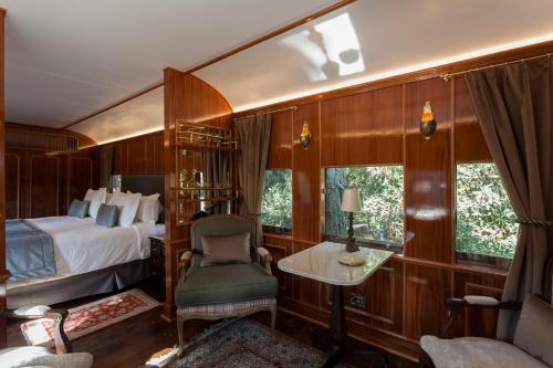 a bedroom with a bed and a chair in a train at Hotel Toriba in Campos do Jordão