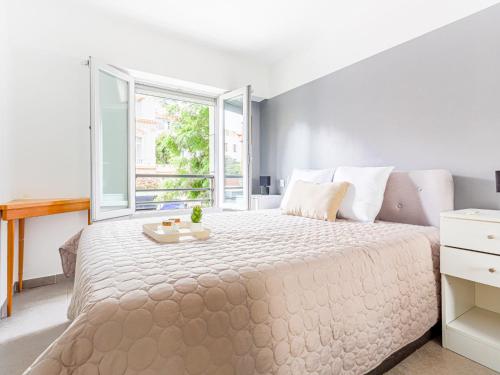 une chambre blanche avec un grand lit et une fenêtre dans l'établissement Apartment Jardin Pastorelli by Interhome, à Nice