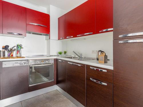 une cuisine équipée de placards rouges et d'appareils en acier inoxydable dans l'établissement Apartment Jardin Pastorelli by Interhome, à Nice