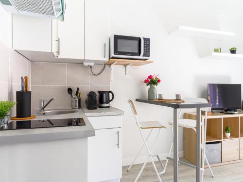 - une cuisine blanche avec une table et un four micro-ondes dans l'établissement Studio Le Maréchal by Interhome, à Nice