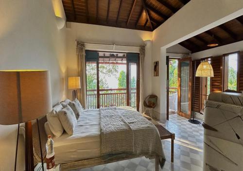 a bedroom with a large bed and a balcony at SaffronStays Stella Maris - Luxury Beach Front Villa Near Redi Beach in Querim