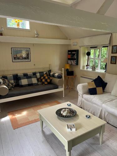 a living room with a couch and a table at The Dairy light and relaxing in Guestling