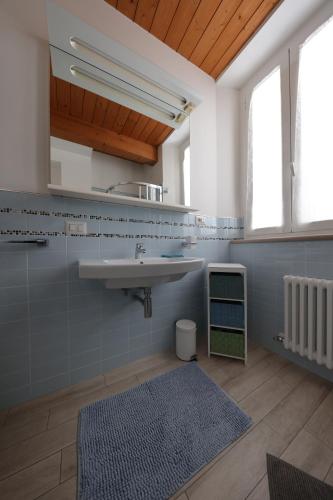 bagno con lavandino e tappeto blu di Residenza La Piazzetta a Porto Recanati