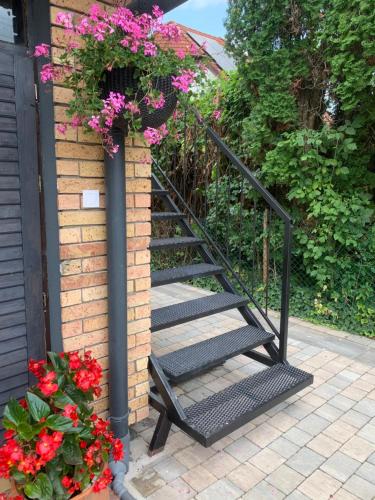 a staircase with flowers on the side of a house at KisPagony Apartman in Kaposvár
