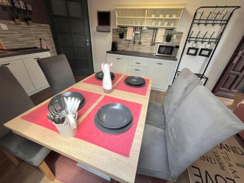 a table with plates and utensils on it in a kitchen at KisPagony Apartman in Kaposvár