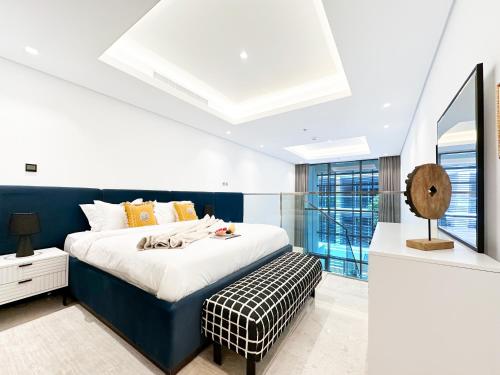 a bedroom with a blue and white bed and a window at Trophy - Elevated Living in Luxurious Business Bay Loft in Dubai