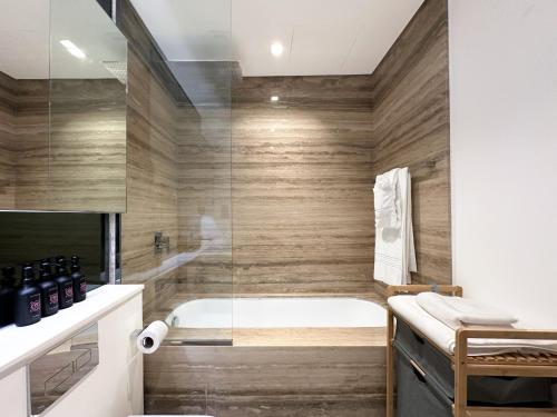 a bathroom with a tub and a glass shower at Trophy - Elevated Living in Luxurious Business Bay Loft in Dubai