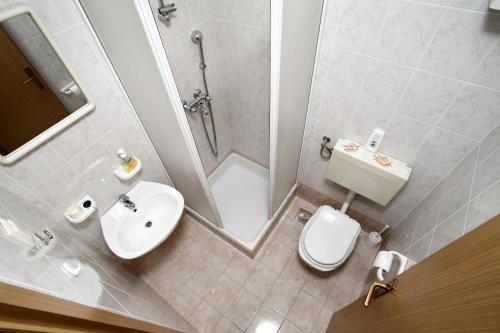 a bathroom with a sink and a toilet and a shower at Apartments in Beautiful Split in Podstrana